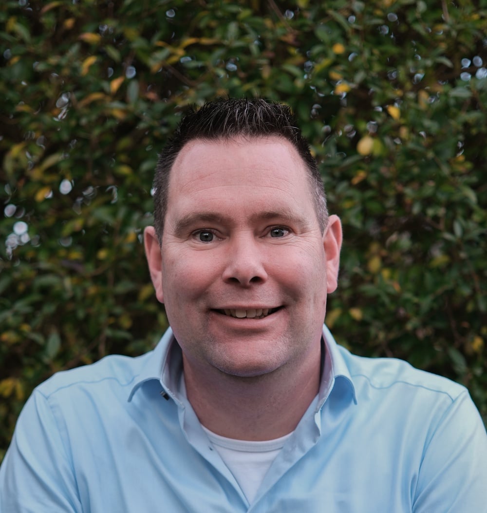 Portret van André Hingstman, Manager Strategische Contracten bij idverde, met groene heg op de achtergrond.