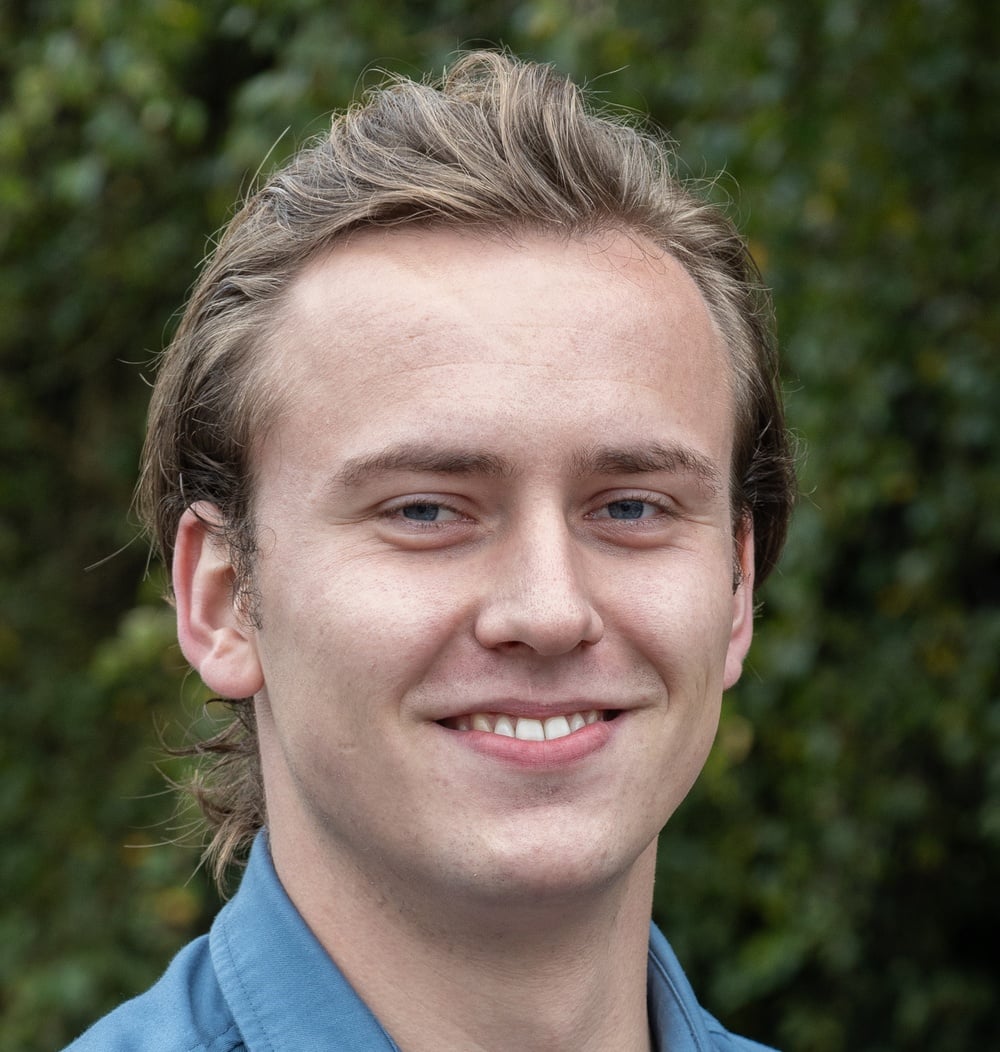 Portret van Bart Boer, projectleider bij idverde, met groene begroeiing op de achtergrond.