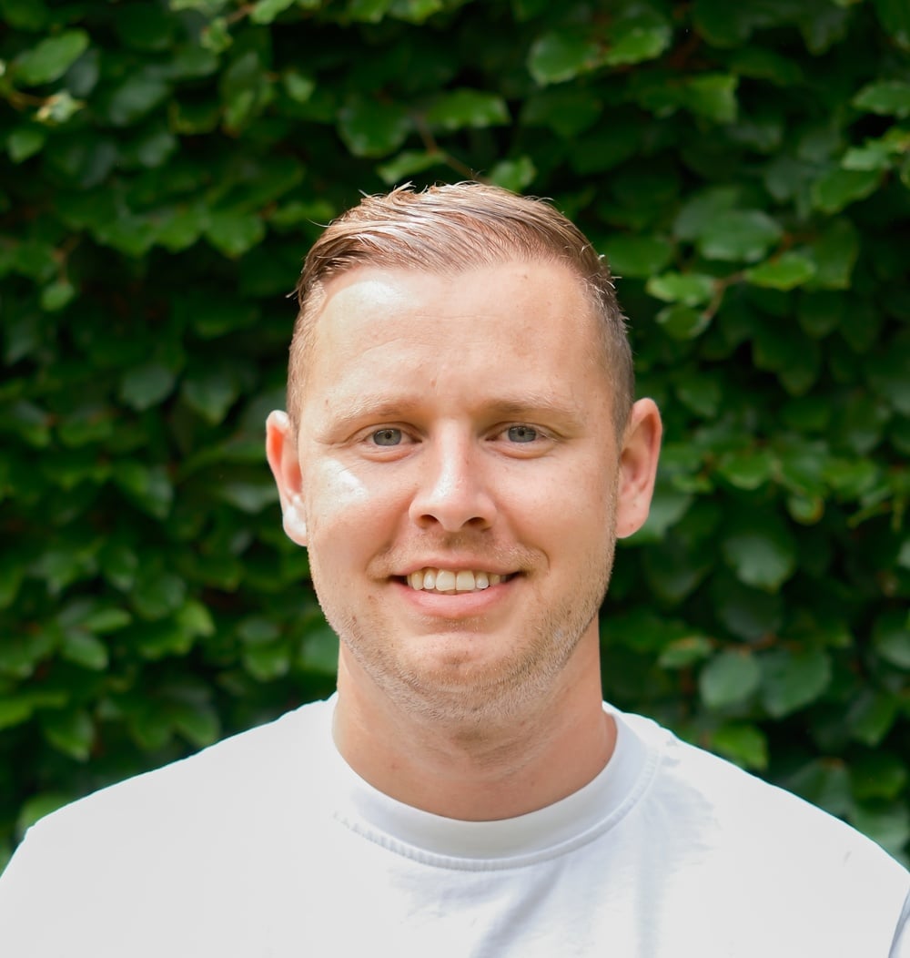 Bas van Popta, uitvoerder bij idverde, poseert voor een groene heg.