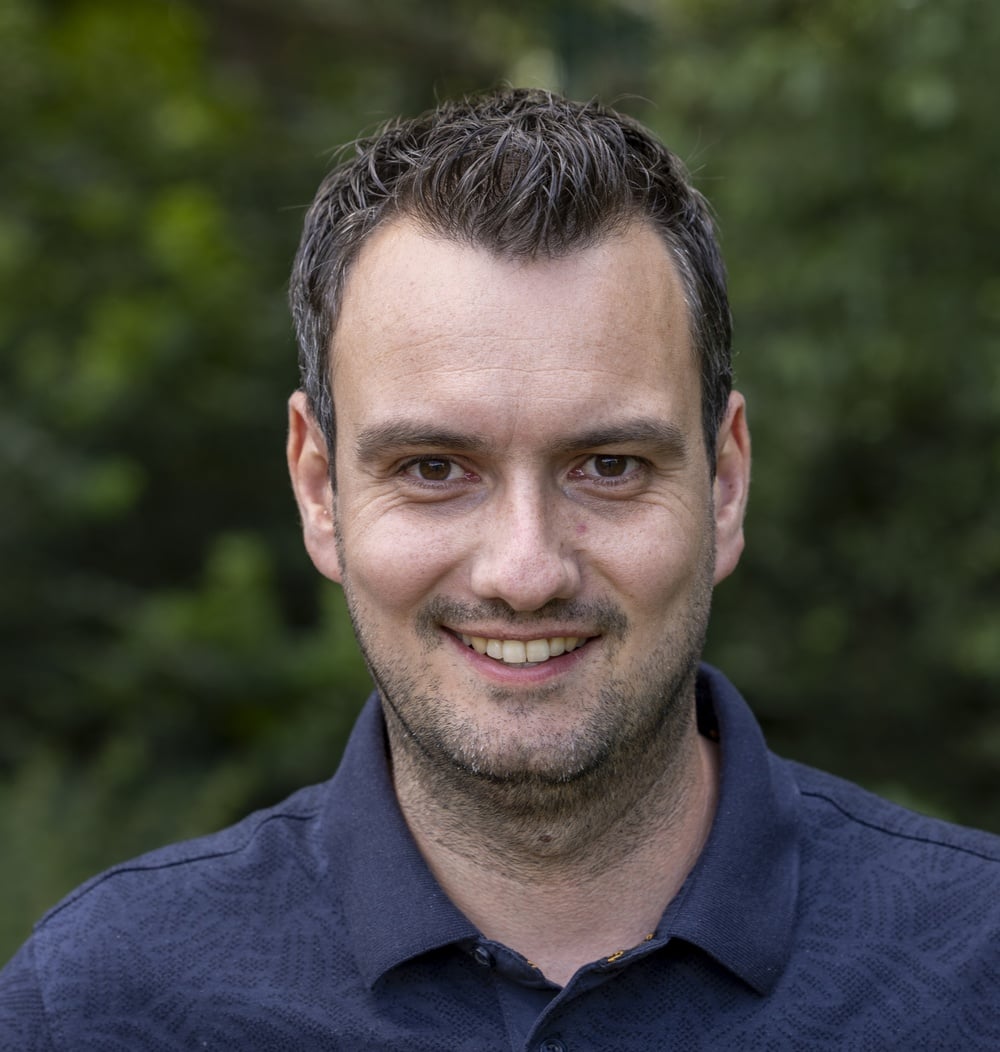 Coen Bal, productmanager Dak- en Gevelgroen bij idverde, portretfoto met groene achtergrond.
