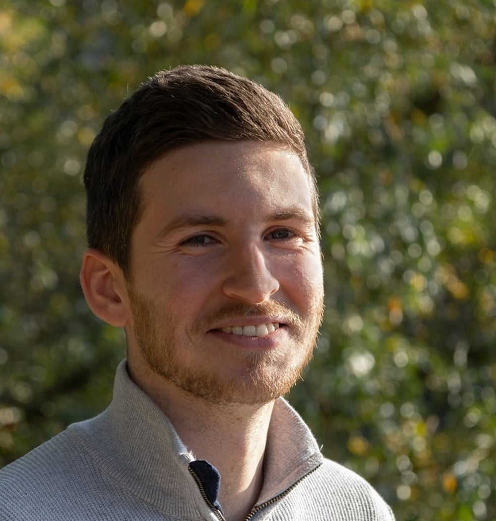 Daan Duijmelinck, adviseur ecologie bij idverde, poserend voor groene achtergrond.