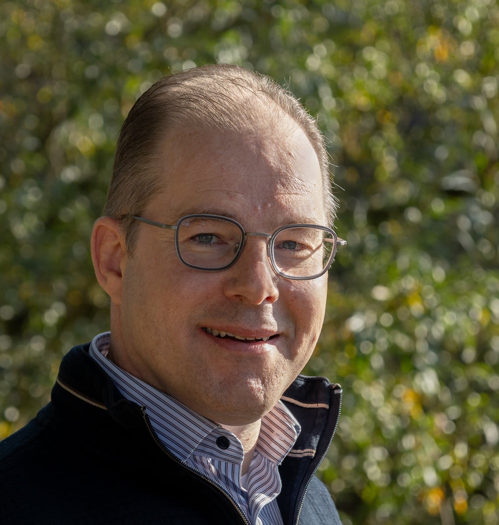Portret van Fedor le Fèbre, adviseur Geo-informatie bij idverde, met groene begroeiing op de achtergrond.