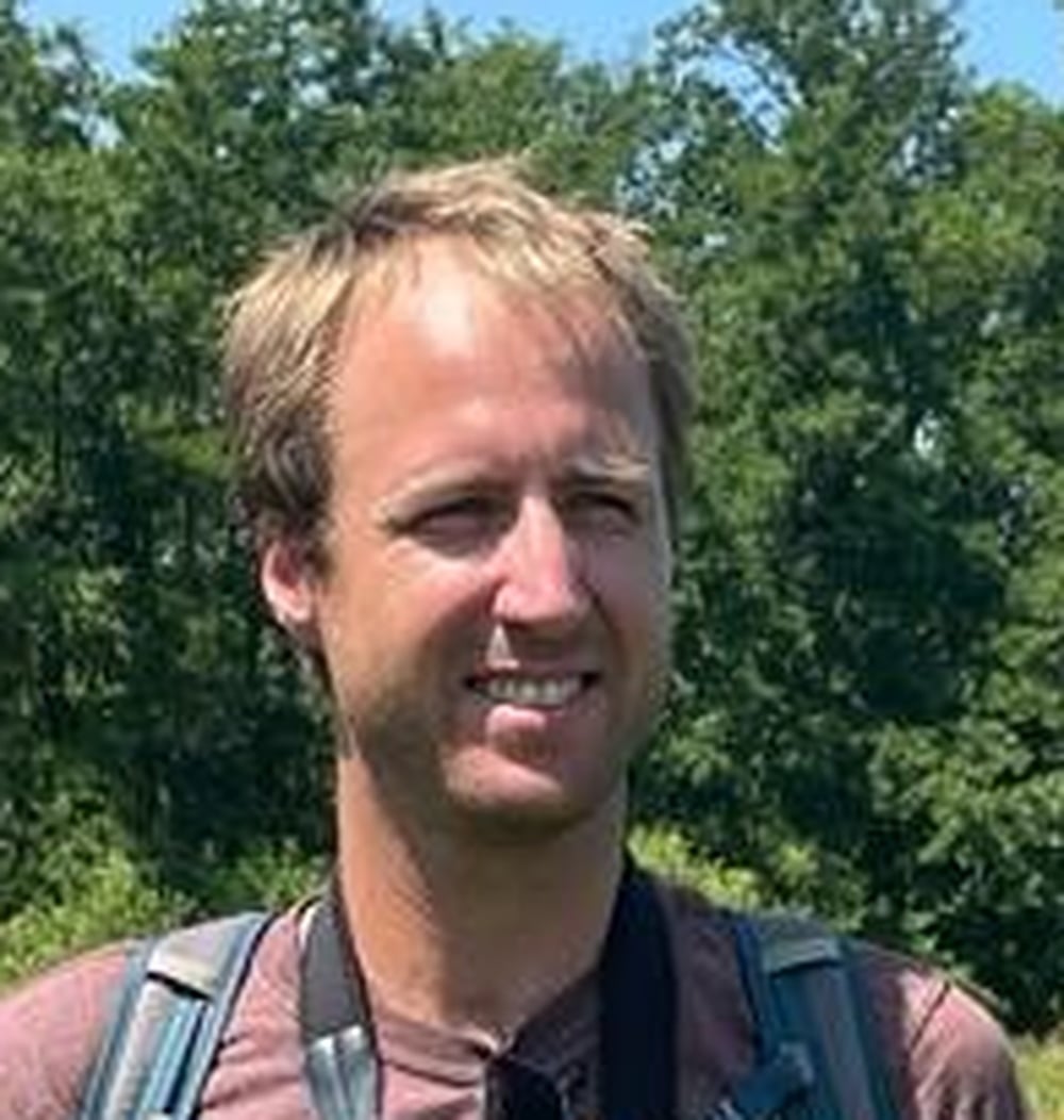 Frank de Weerd, adviseur ecologie bij idverde, buiten met bomen op de achtergrond.