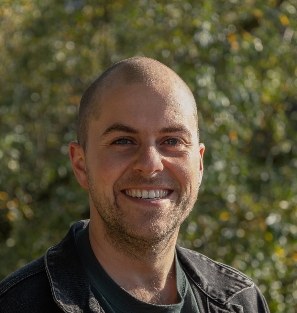 Geert Coehorst, adviseur Engineering & Contracten bij idverde, met groene beplanting op de achtergrond.