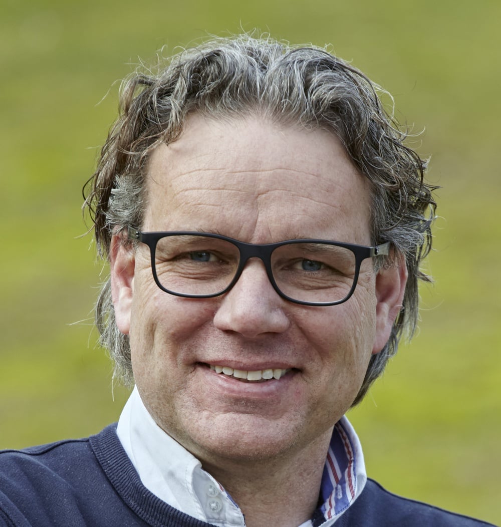 Gertjan Klein Legtenberg, vestigingsmanager bij idverde, portretfoto voor groene achtergrond.