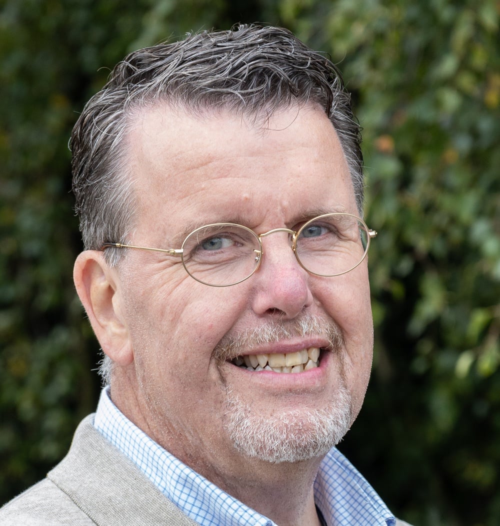 Gertjan Klein Legtenberg, vestigingsmanager bij idverde, portretfoto voor groene achtergrond.