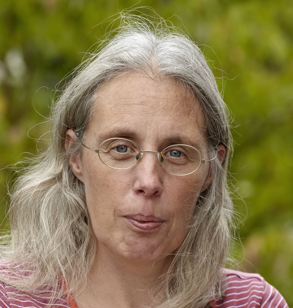 Ingeborg Bax, adviseur sr. Ecologie bij idverde, portret met groene begroeiing op de achtergrond.