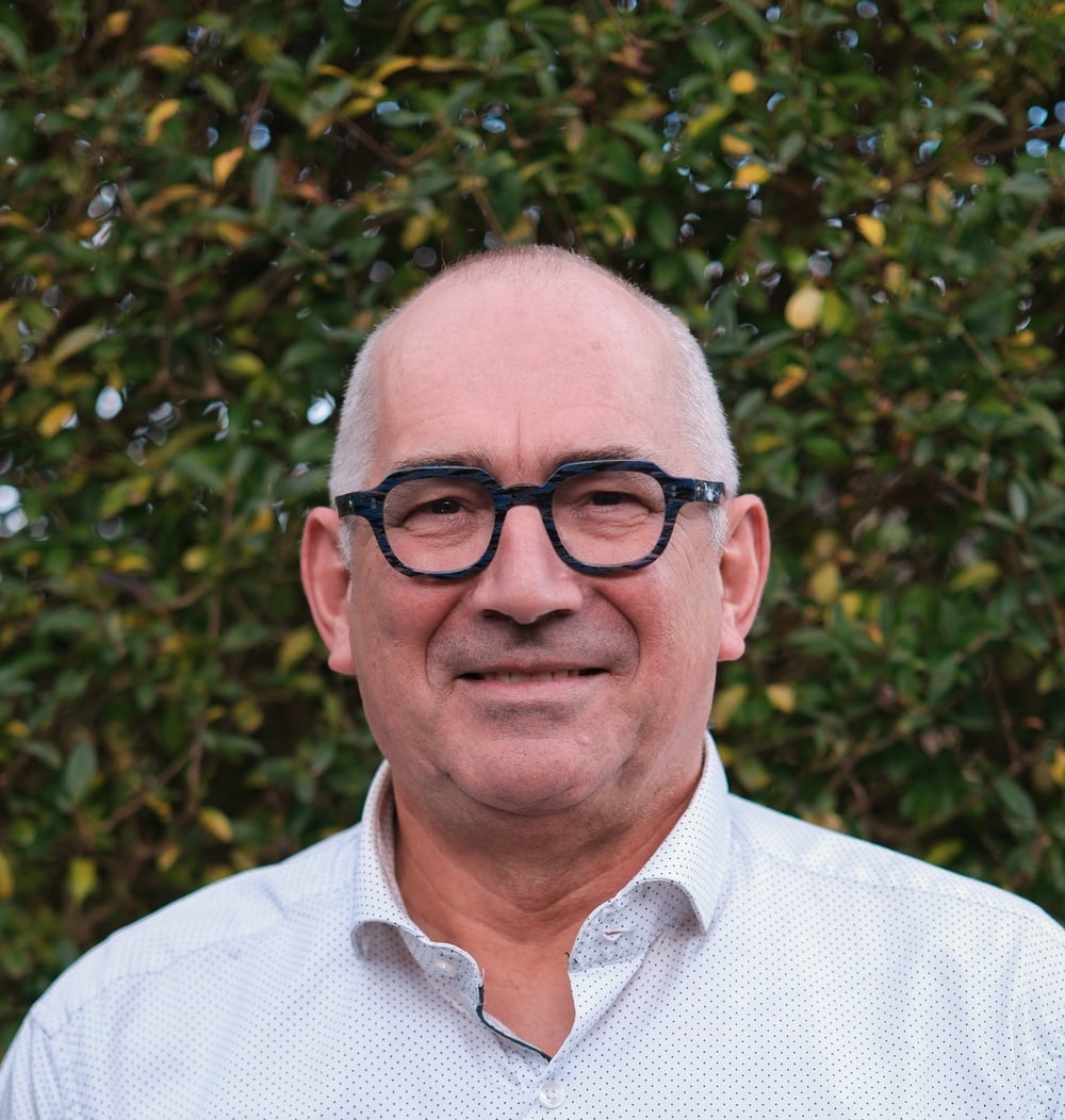 Portret van Jos Spooren, vestigingsmanager bij idverde, voor een groene heg.