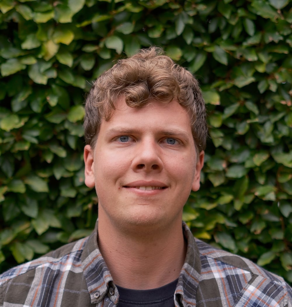 Marijn de Waard, adviseur Ecologie bij idverde, poseert voor een groene heg.