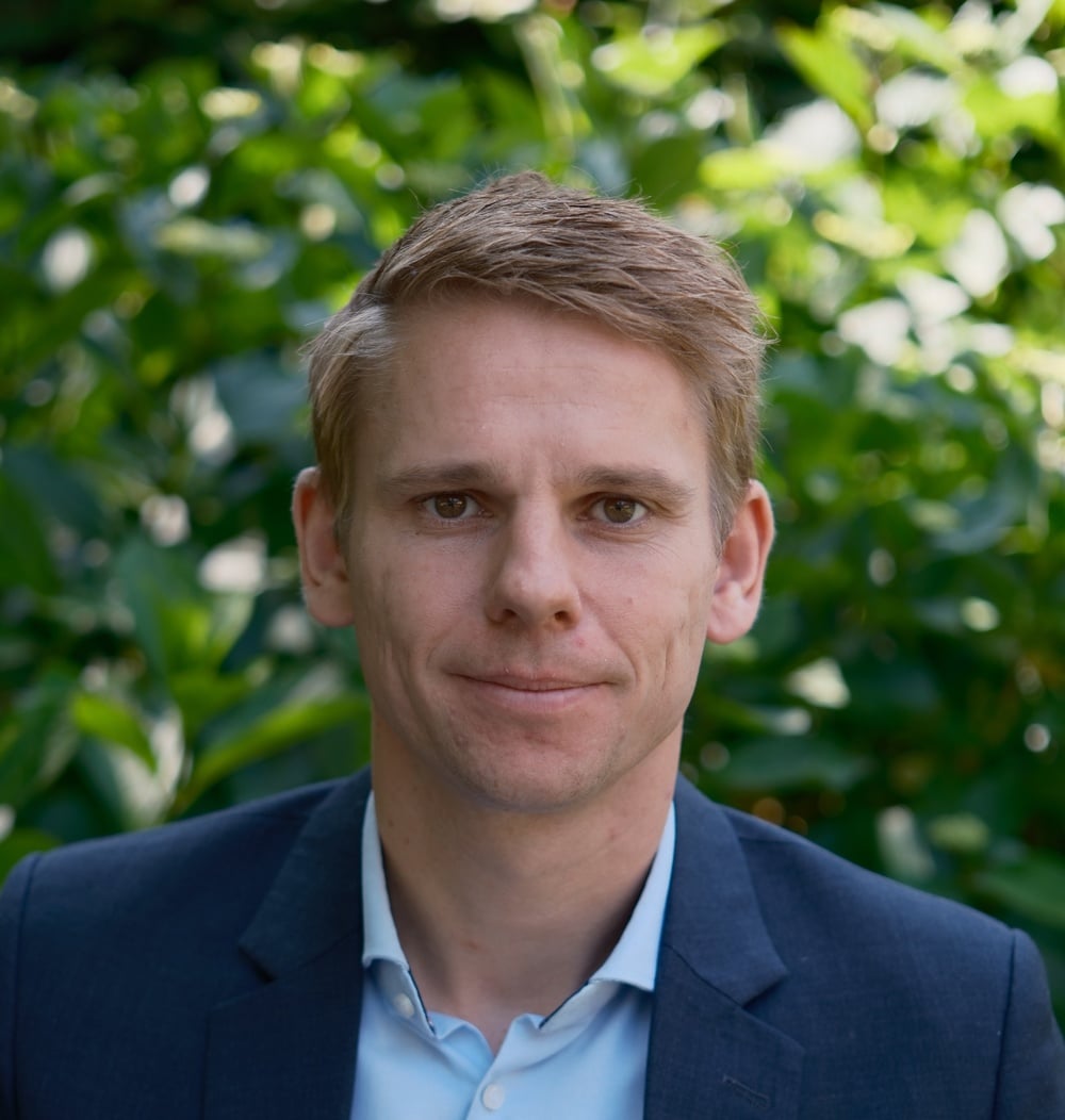 Portret van Michiel Hoekstra, CFO, tegen een groene bladerachtergrond.