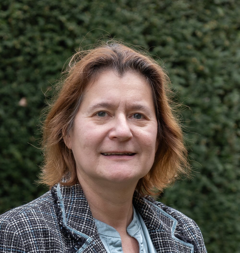 Portret van Monique van der Mullen - van Buul, Legal Counsel, voor een groene heg.