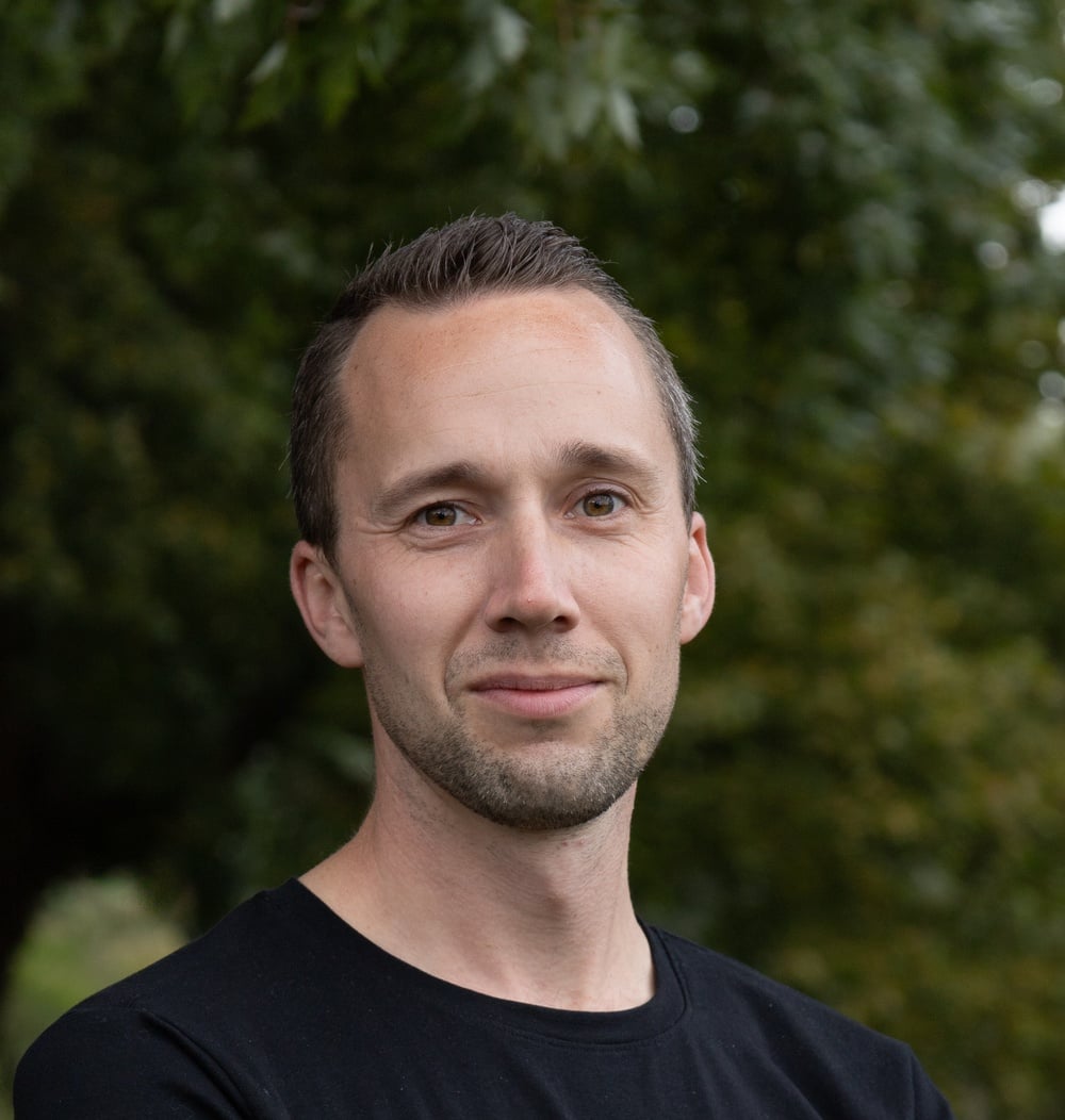 Pim de Boer, projectleider bij idverde, buiten voor groene begroeiing.