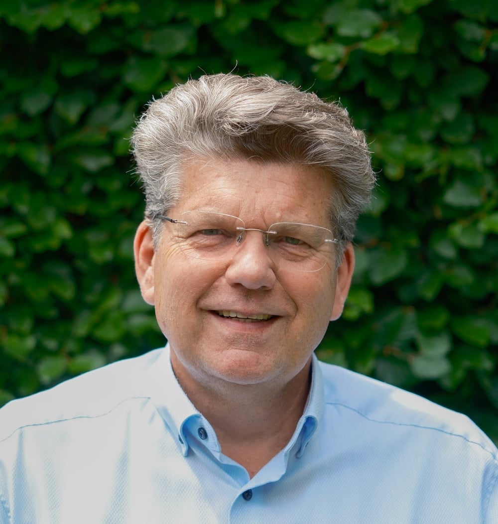 Richard Stockmann, vestigingsmanager bij idverde, poseert voor een groene heg.