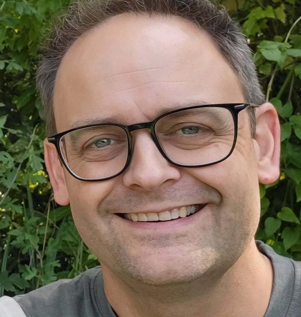Roeland Pullen, adviseur Dak- en Gevelgroen bij idverde, glimlachend voor groene begroeiing.