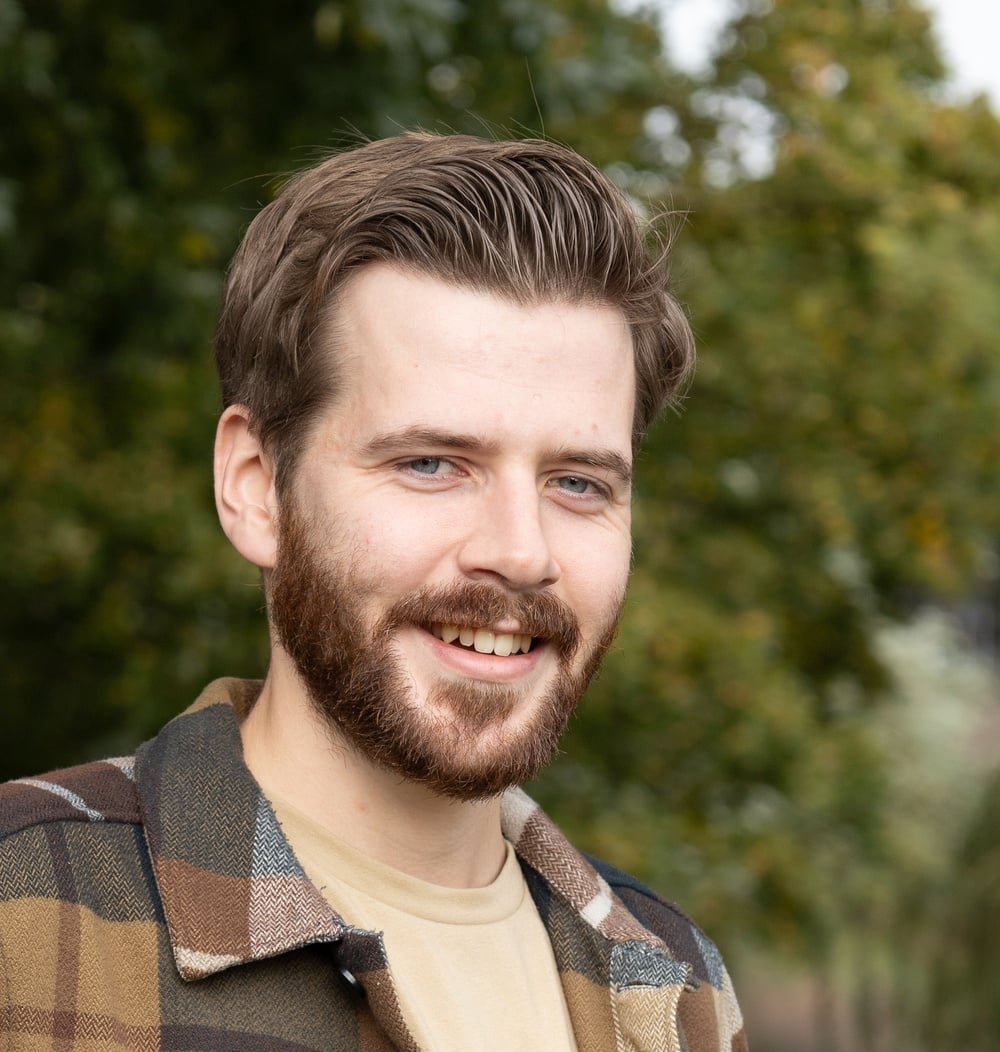 Ruben van Laar, adviseur ecologie bij idverde, buiten met bomen op de achtergrond.