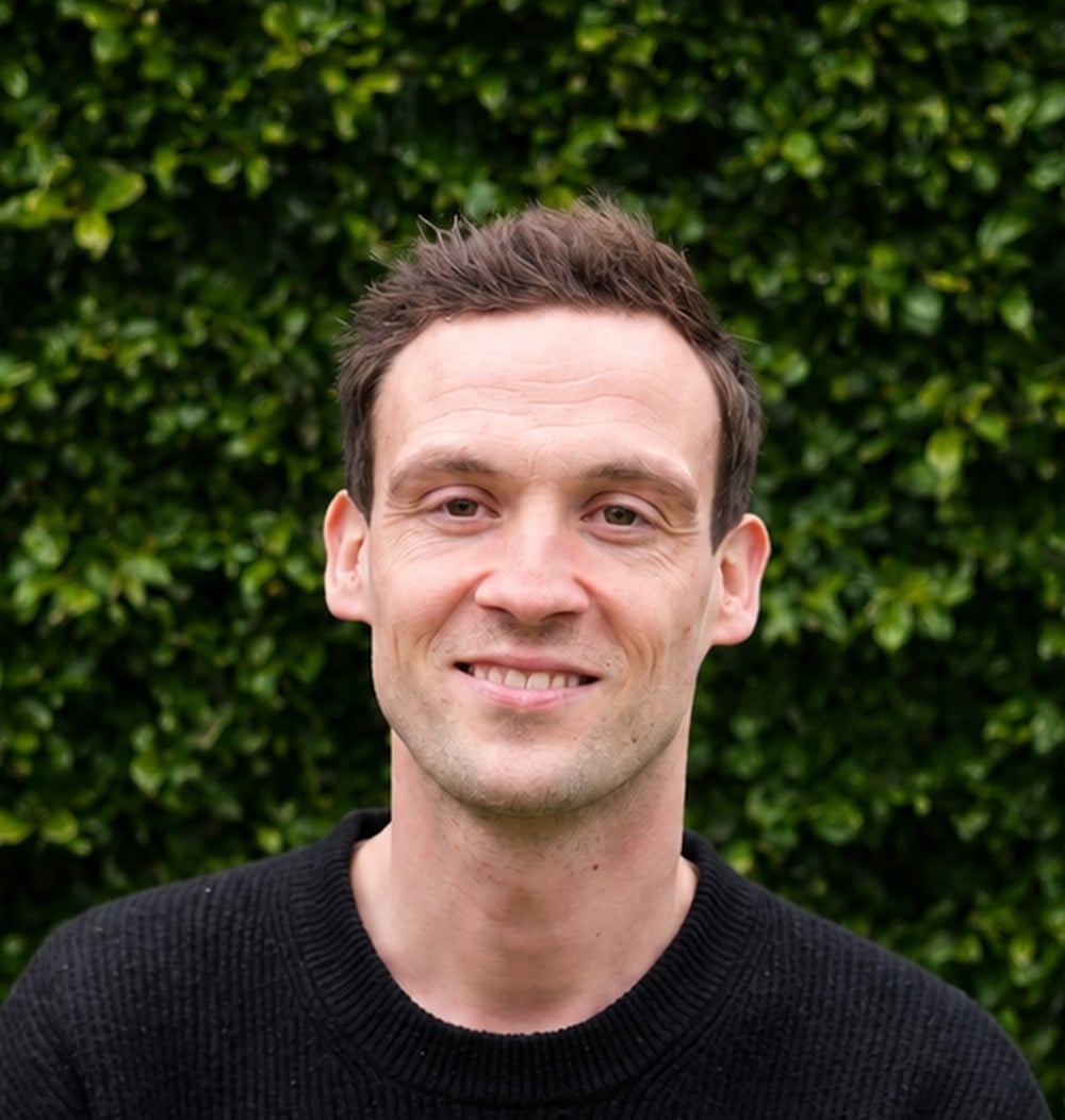 Stefan Ruijs, projectleider bij idverde, poseert voor een groene heg.