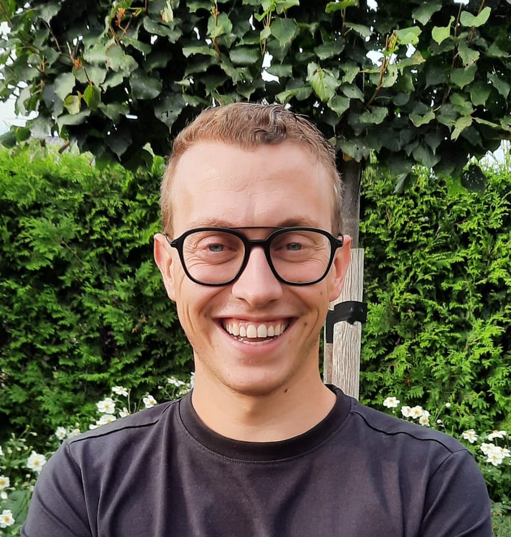 Victor Hurxkens, adviseur Beheeradvisering & Contracten bij idverde, lachend op de foto voor een groene heg.