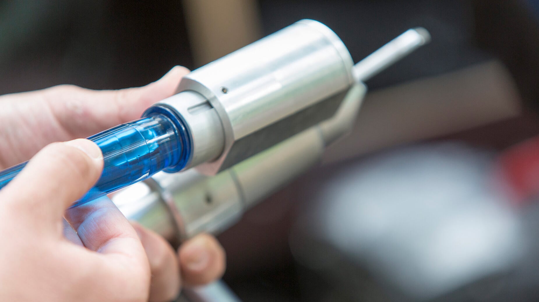Medewerker sluit een injectienaald aan op metalen apparatuur voor boombehandeling.