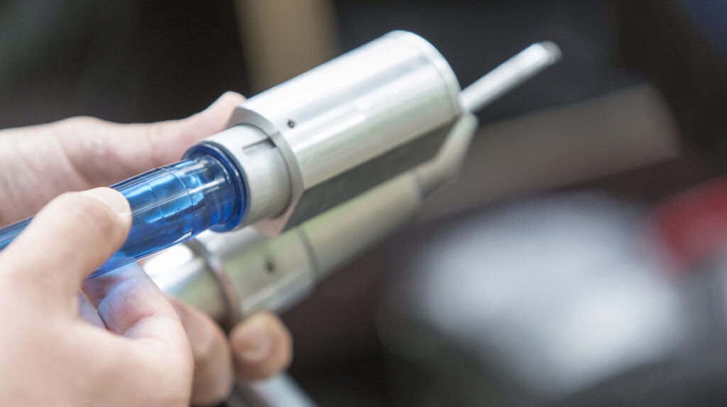 Medewerker plaatst een injectienaald in een boominjectiesysteem ter bescherming van een iep.