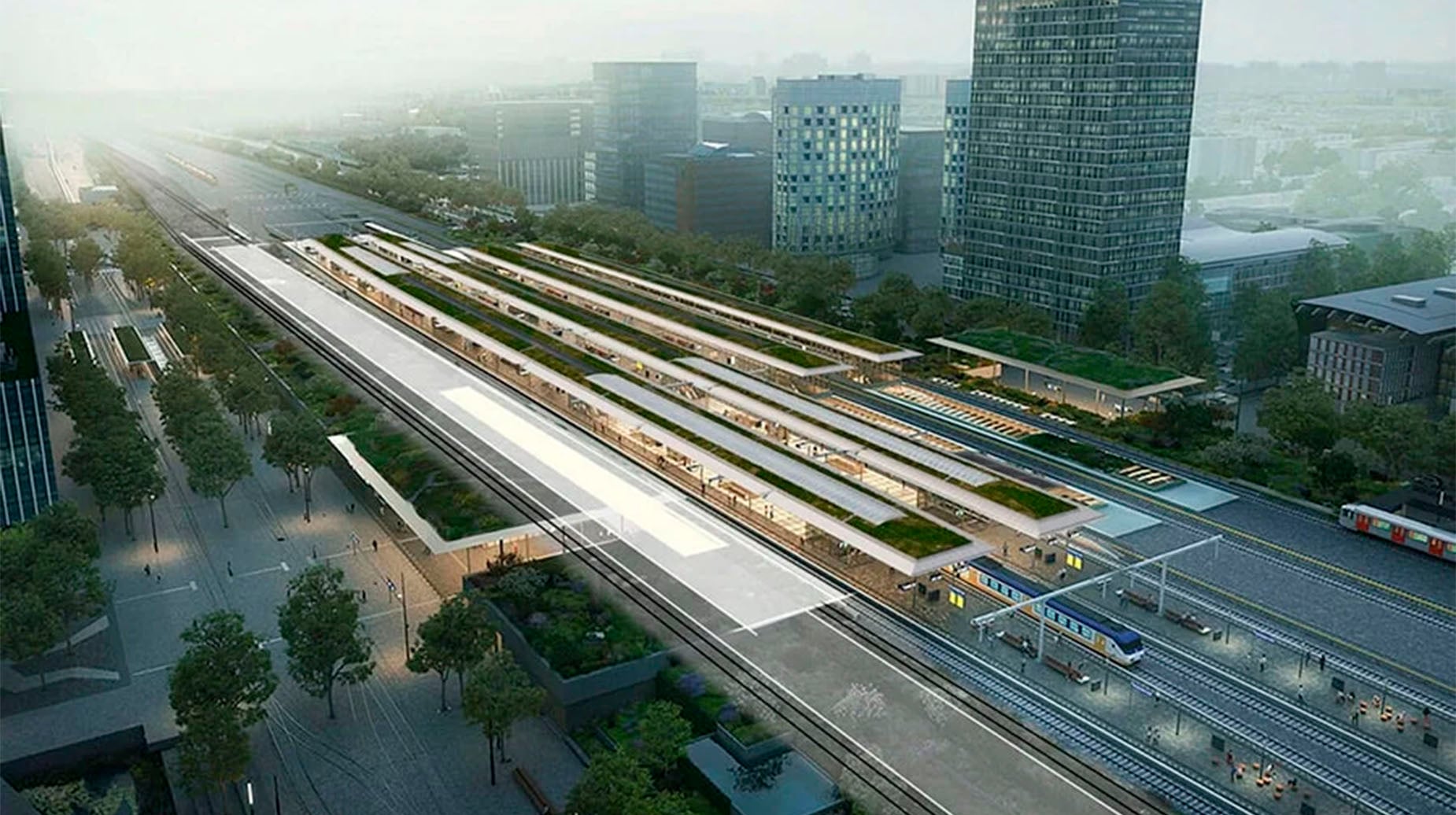 Luchtfoto van treinstation met groene daken tussen hoogbouw in de stad.