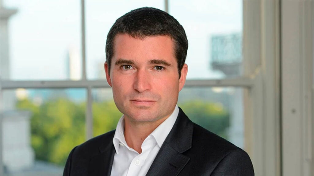Portretfoto van de nieuwe CEO van idverde Group in zakelijk pak voor een raam